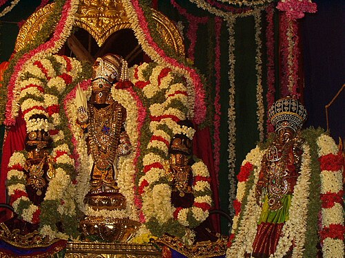 A Hindu murti of Vishnu covered in flower garlands