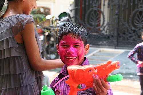 Crowds covered in coloured powders during the Holi festival